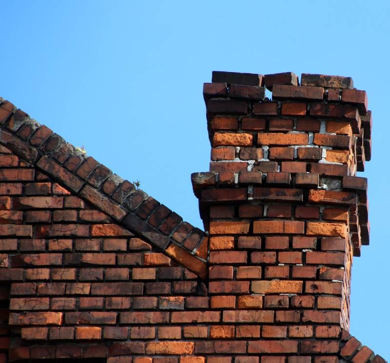 Damaged chimney on an Hudson Mills home showing cracks and missing mortar